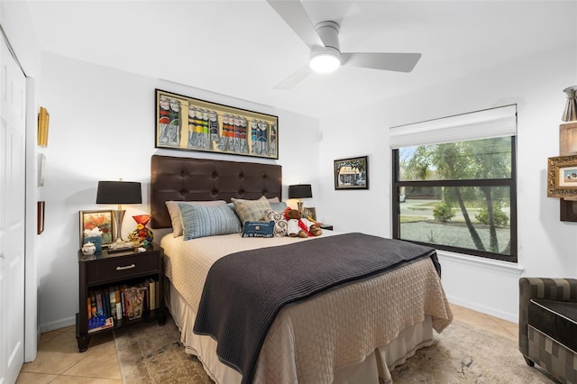 bedroom with ceiling fan, light tile patterned floors, and a closet