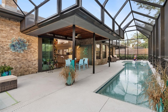 view of pool with a lanai, a patio area, ceiling fan, and an outdoor living space