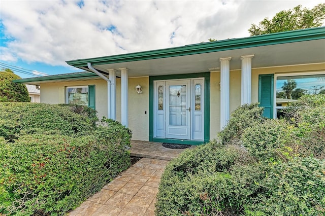 view of exterior entry with stucco siding