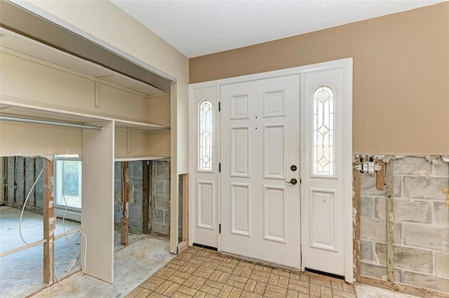 entrance foyer featuring a textured ceiling and a healthy amount of sunlight