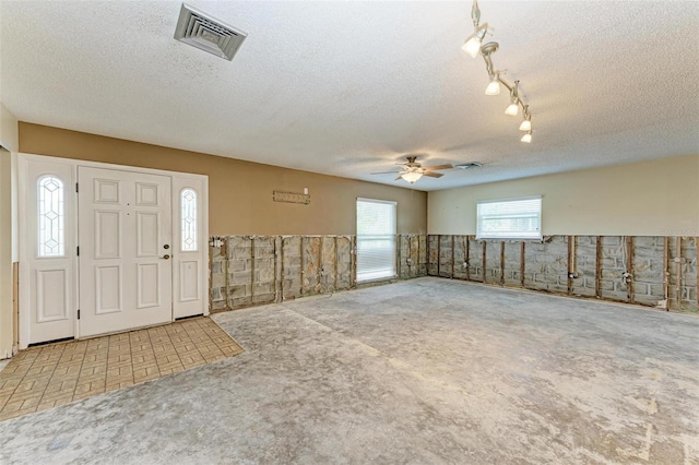 carpeted entrance foyer with ceiling fan and a textured ceiling