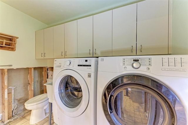 laundry area with cabinets, light tile patterned flooring, and washer and dryer