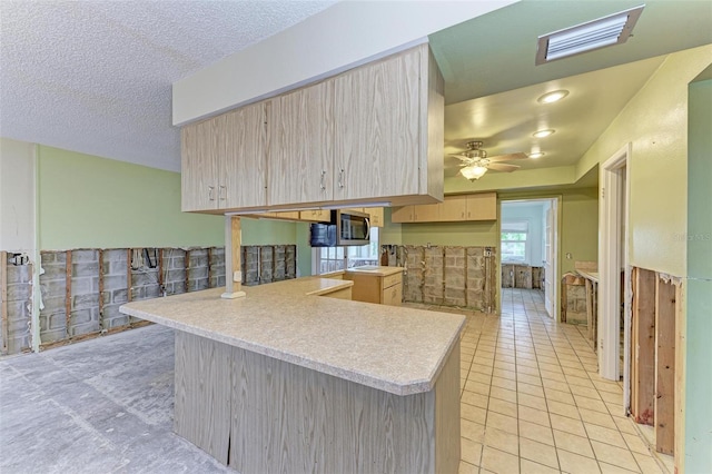 kitchen with kitchen peninsula, ceiling fan, light brown cabinets, and light tile patterned floors