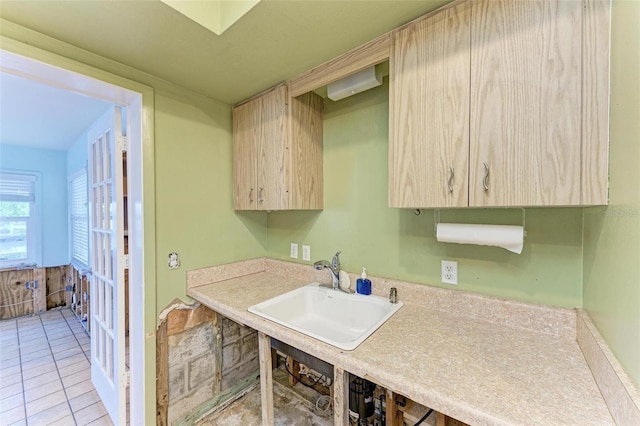 kitchen featuring light brown cabinetry, light tile patterned floors, and sink