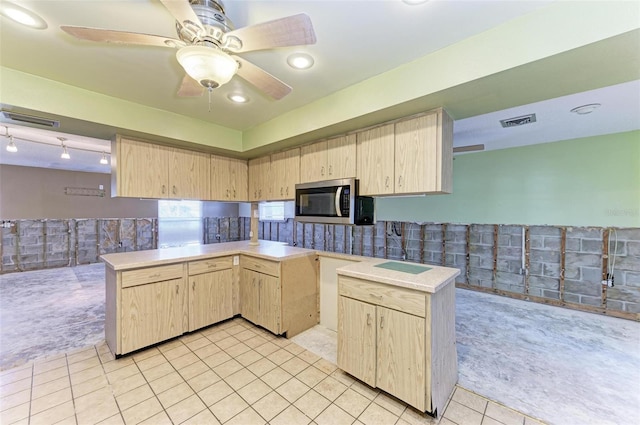 kitchen with kitchen peninsula, light brown cabinetry, and light tile patterned flooring