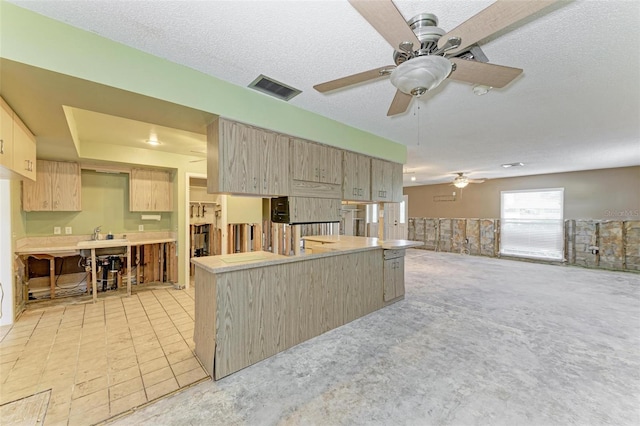 kitchen featuring light brown cabinets, ceiling fan, a textured ceiling, light tile patterned flooring, and kitchen peninsula