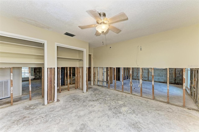 miscellaneous room featuring a textured ceiling, carpet floors, and ceiling fan