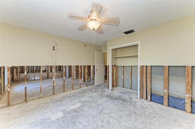 unfurnished bedroom featuring ceiling fan, a closet, light carpet, and a textured ceiling