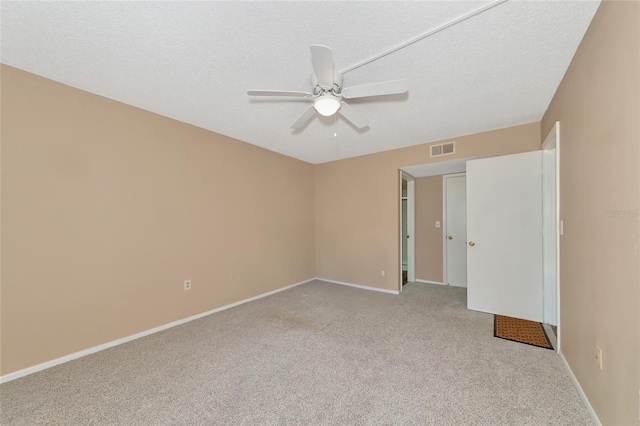 spare room with a textured ceiling, ceiling fan, and light carpet