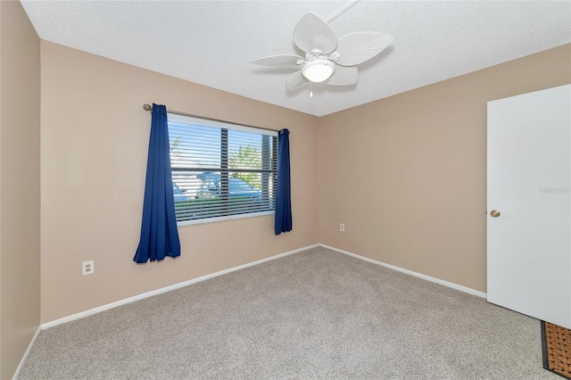 empty room featuring a textured ceiling, ceiling fan, and light carpet