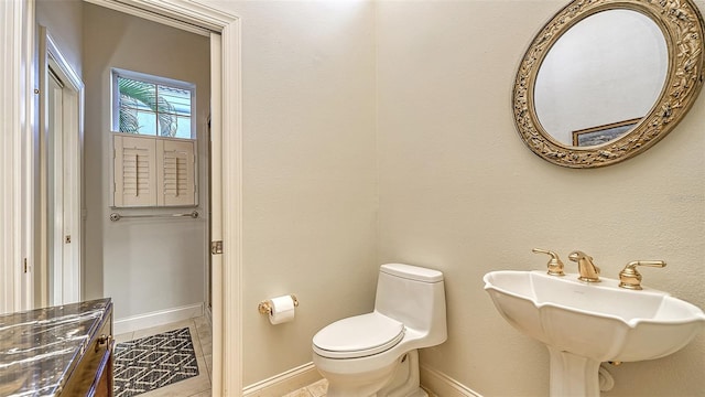 bathroom featuring tile patterned flooring, toilet, and sink