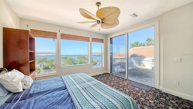 bedroom featuring carpet flooring, ceiling fan, a water view, and access to outside