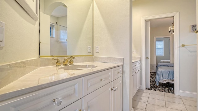 bathroom with tile patterned floors, vanity, and a chandelier