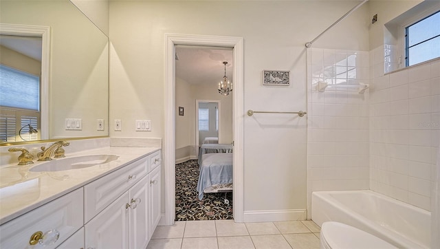 full bathroom with vanity, tile patterned flooring, tiled shower / bath combo, toilet, and a notable chandelier