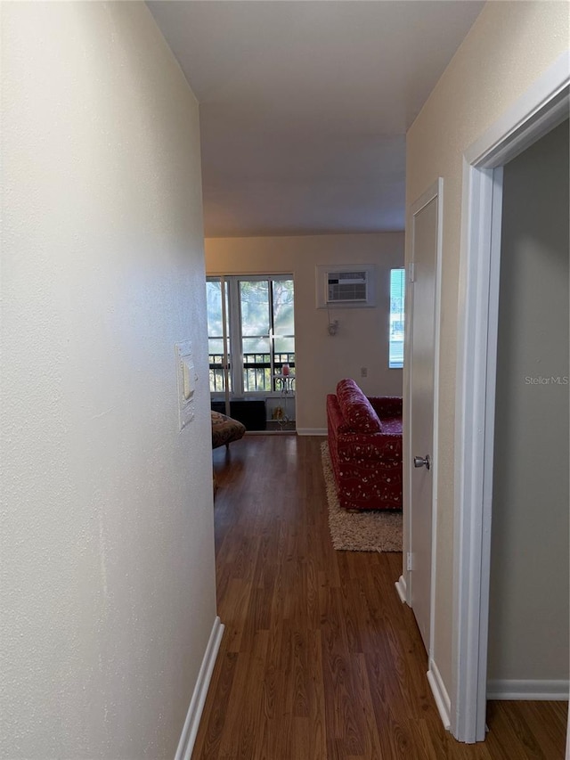 hallway featuring a wall mounted air conditioner and dark hardwood / wood-style flooring