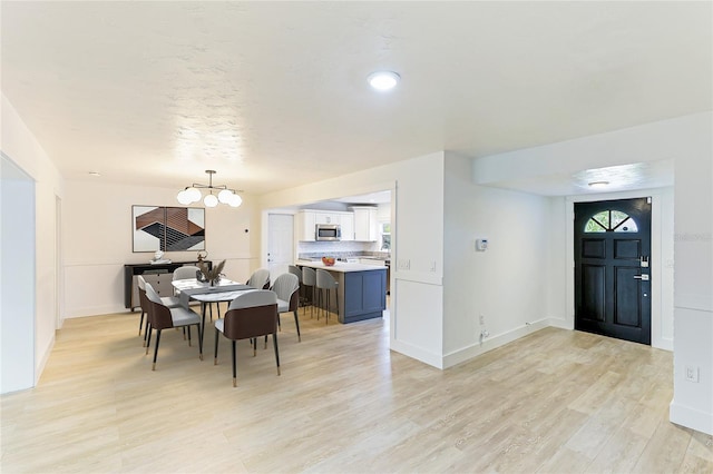 dining room featuring light hardwood / wood-style flooring and a notable chandelier