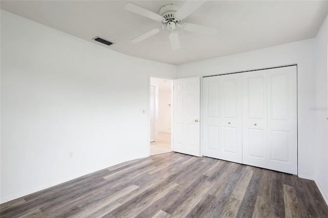 unfurnished bedroom featuring hardwood / wood-style floors, a closet, and ceiling fan