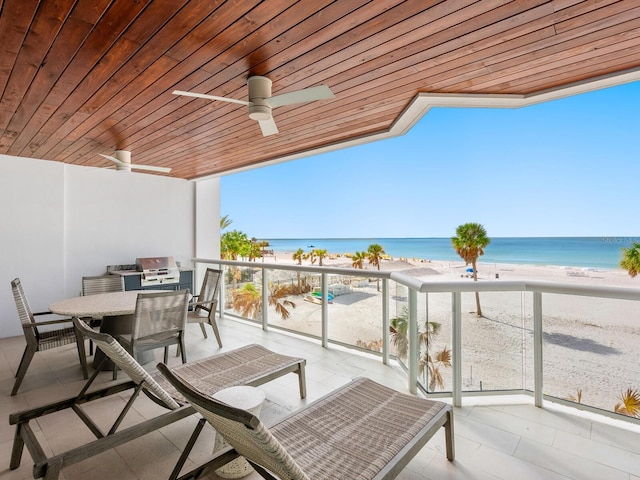 balcony featuring a water view, ceiling fan, and a view of the beach