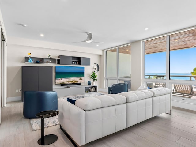 living room featuring ceiling fan and light hardwood / wood-style flooring