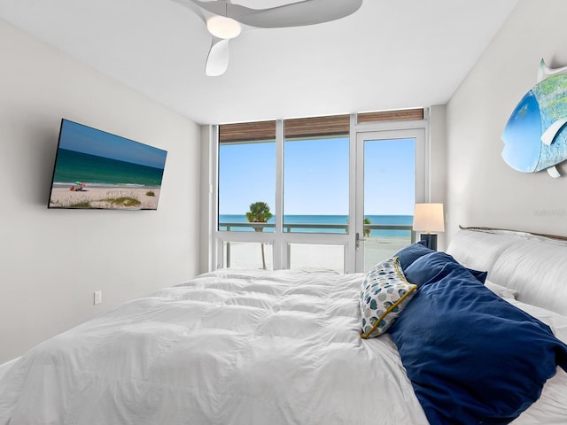 bedroom featuring ceiling fan and a water view