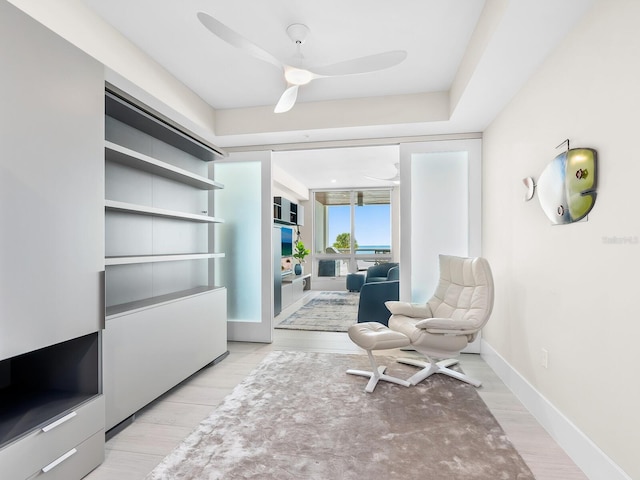 sitting room with light hardwood / wood-style flooring and ceiling fan