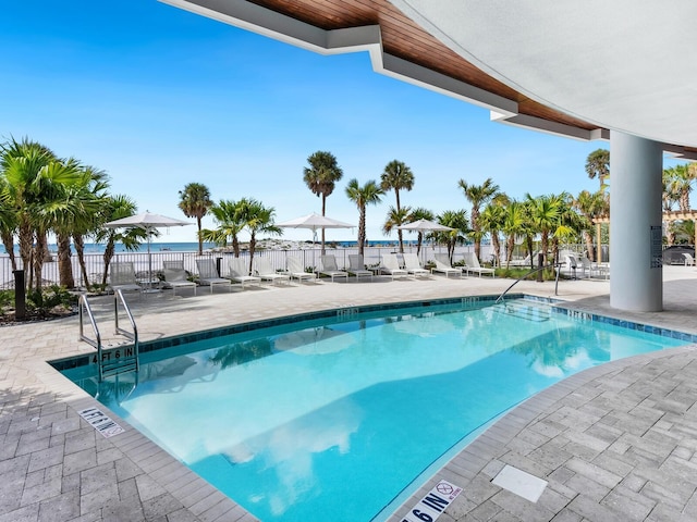 view of pool with a patio and a water view