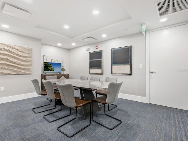 carpeted dining room featuring a raised ceiling