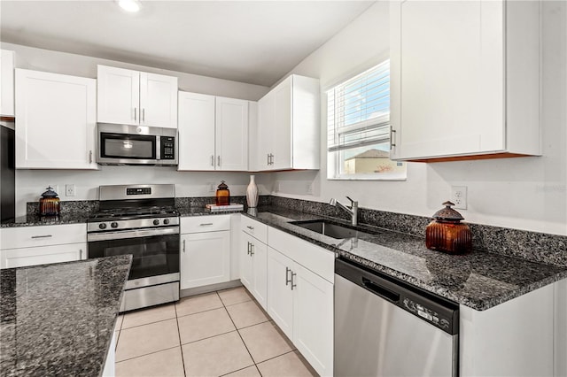 kitchen featuring white cabinets, sink, appliances with stainless steel finishes, and dark stone counters