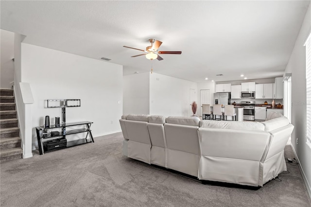 carpeted living room featuring ceiling fan