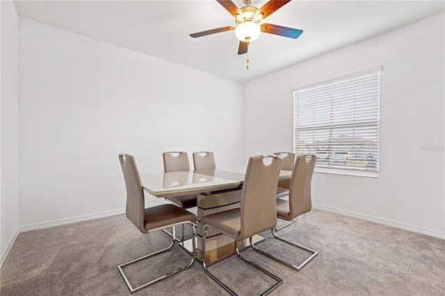 carpeted dining space with ceiling fan