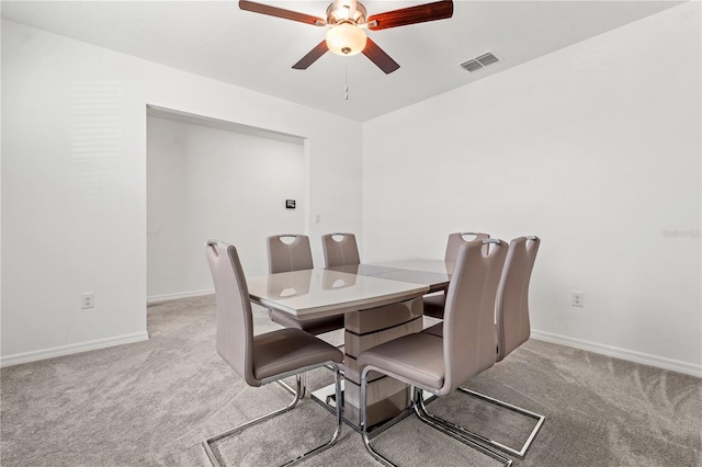 dining area with light carpet and ceiling fan