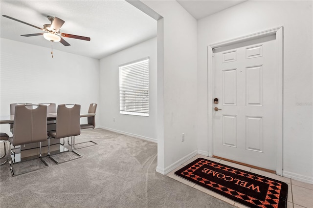 carpeted entryway featuring ceiling fan