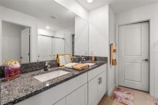 bathroom featuring tile patterned floors, vanity, and a shower with door