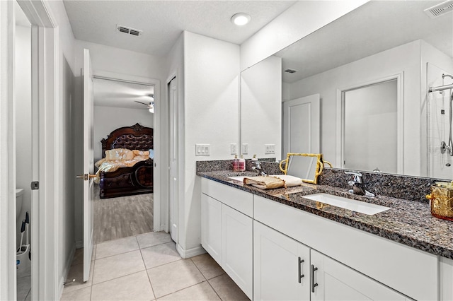 bathroom with tile patterned flooring, vanity, and ceiling fan