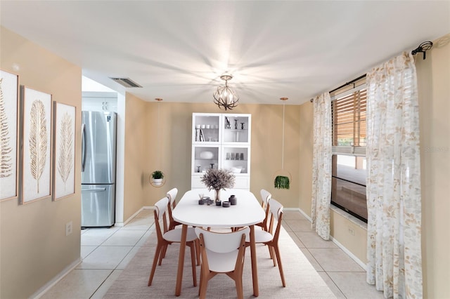 dining area featuring a notable chandelier and light tile patterned flooring