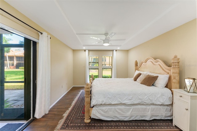 bedroom with ceiling fan, dark hardwood / wood-style floors, access to exterior, and multiple windows