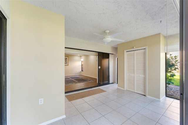 interior space with ceiling fan and a textured ceiling