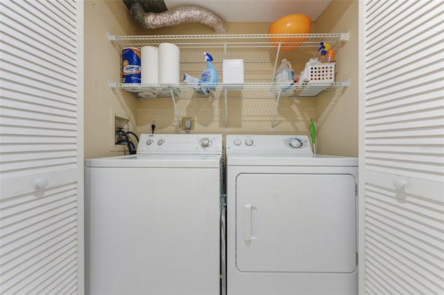 laundry area featuring washing machine and clothes dryer and a textured ceiling