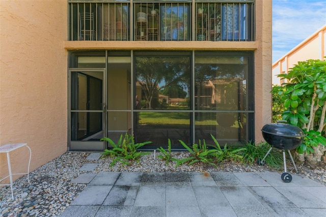 view of exterior entry with a patio area