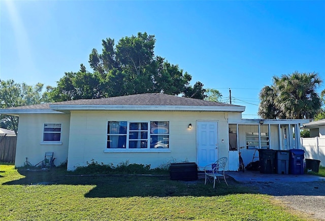 back of house featuring a lawn