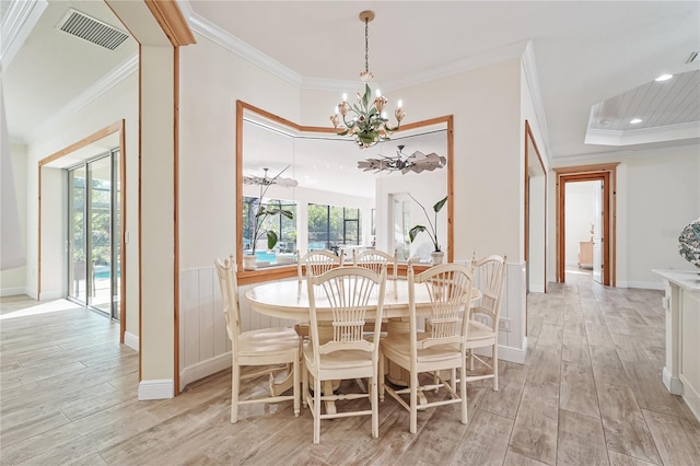 dining area featuring ceiling fan with notable chandelier, light hardwood / wood-style flooring, and crown molding