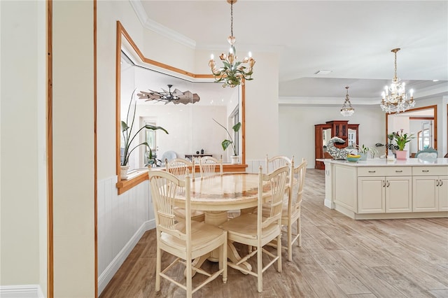 dining area featuring light hardwood / wood-style flooring, ornamental molding, and an inviting chandelier