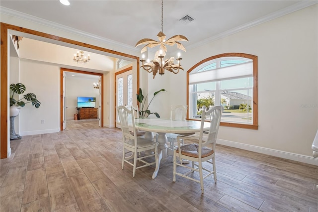 dining area with light hardwood / wood-style floors, a notable chandelier, and ornamental molding