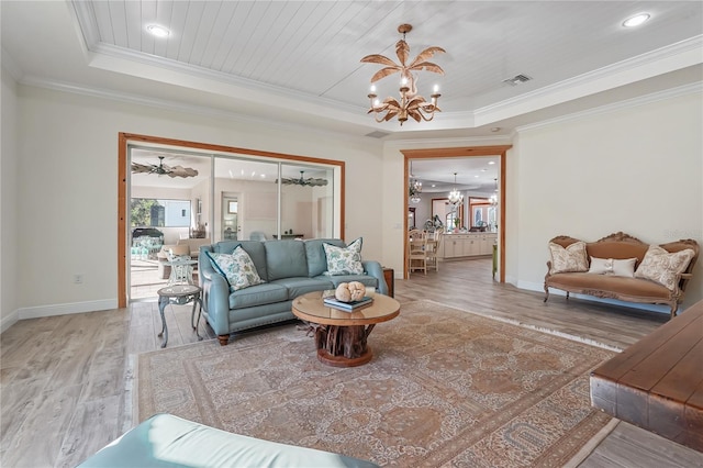 living room with a raised ceiling, hardwood / wood-style floors, and ornamental molding