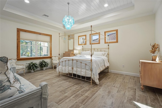 bedroom featuring a raised ceiling, an inviting chandelier, light wood-type flooring, and ornamental molding