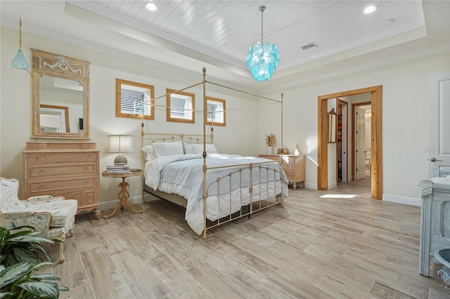 bedroom with a tray ceiling, crown molding, and light hardwood / wood-style flooring