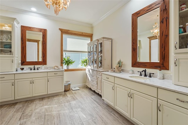 bathroom with a chandelier, vanity, and crown molding