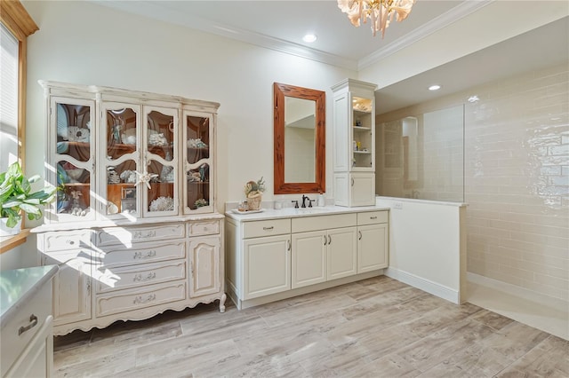 bathroom with vanity, a shower, ornamental molding, and a chandelier