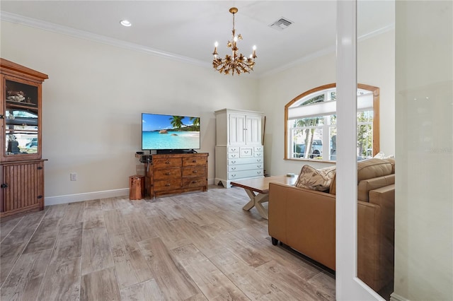 living room with light hardwood / wood-style flooring, ornamental molding, and a notable chandelier