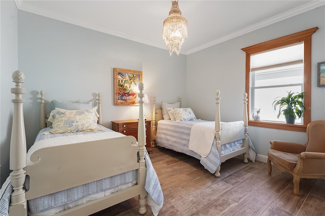 bedroom featuring hardwood / wood-style floors, an inviting chandelier, and crown molding